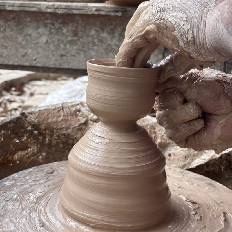Hand shaping raw clay pottery on the wheel in Huaning, Yunnan
