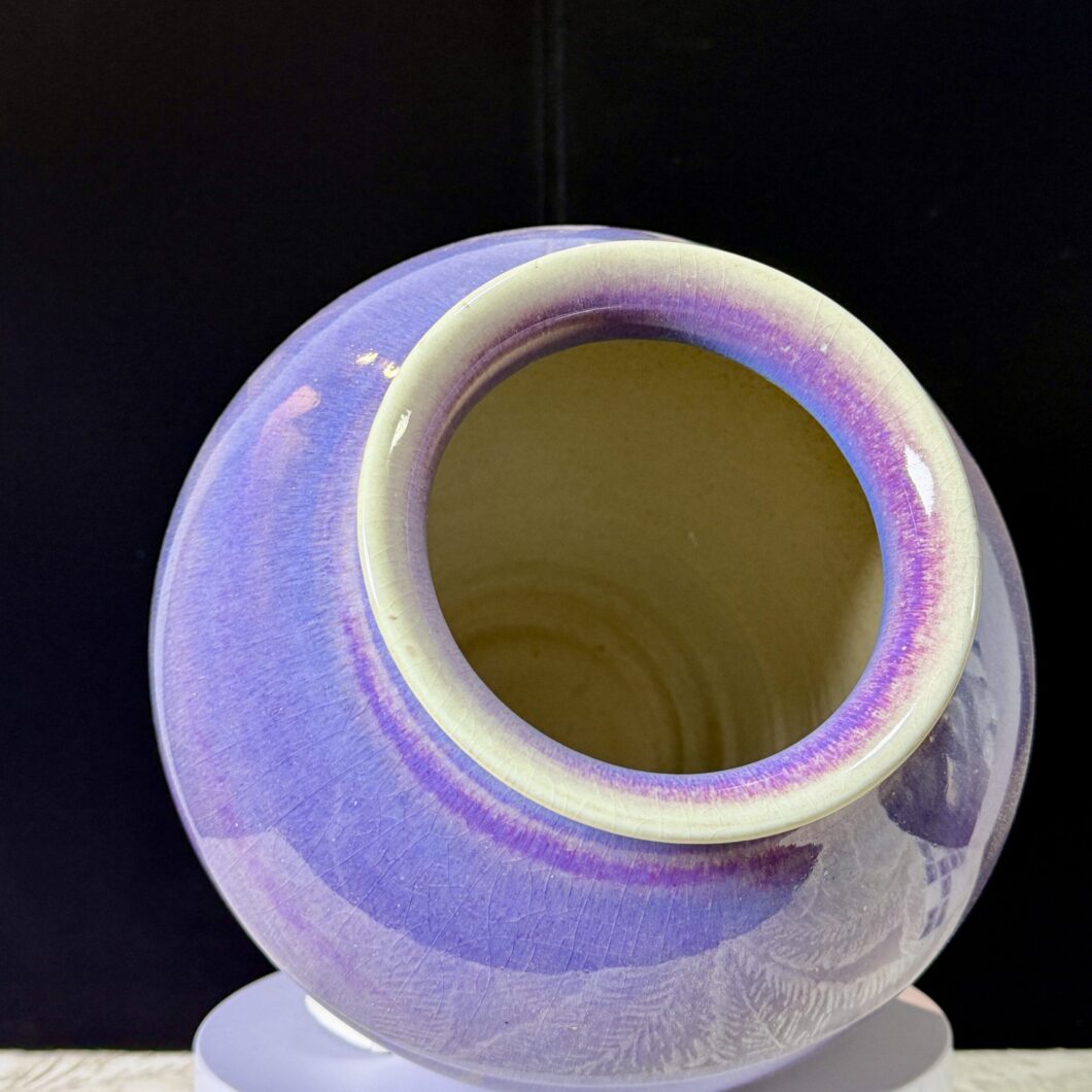 Interior view of a glowing orange ceramic kiln, showing the intense heat and flame during the 1300°C firing process for stoneware vases.