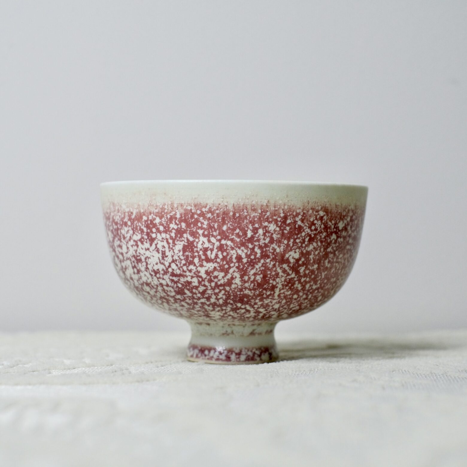 Handmade Yunnan ceramic tea bowl with red speckled glaze, artisan pottery cup