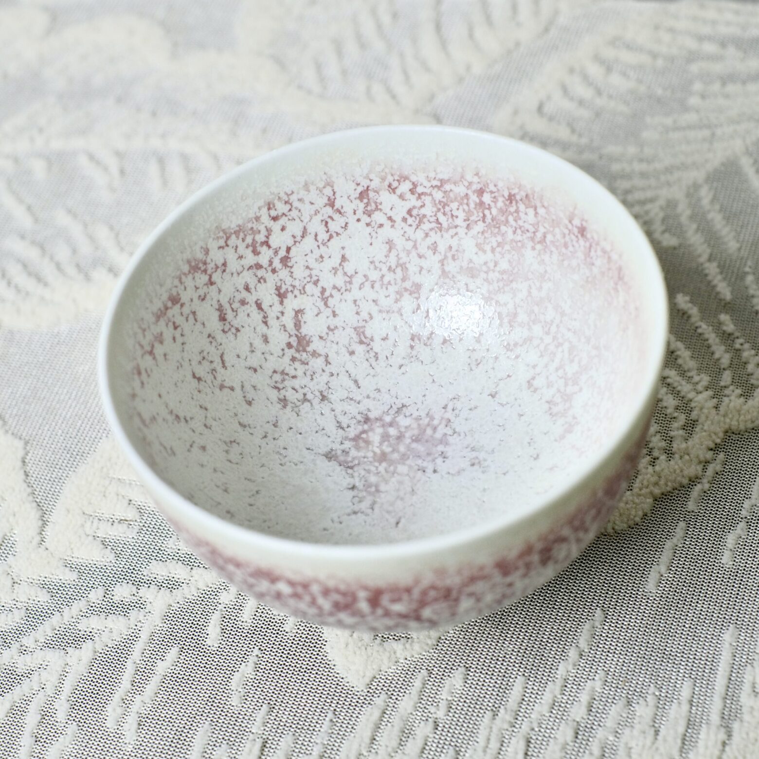 Top view of handmade ceramic tea bowl with textured red glaze interior, Yunnan China