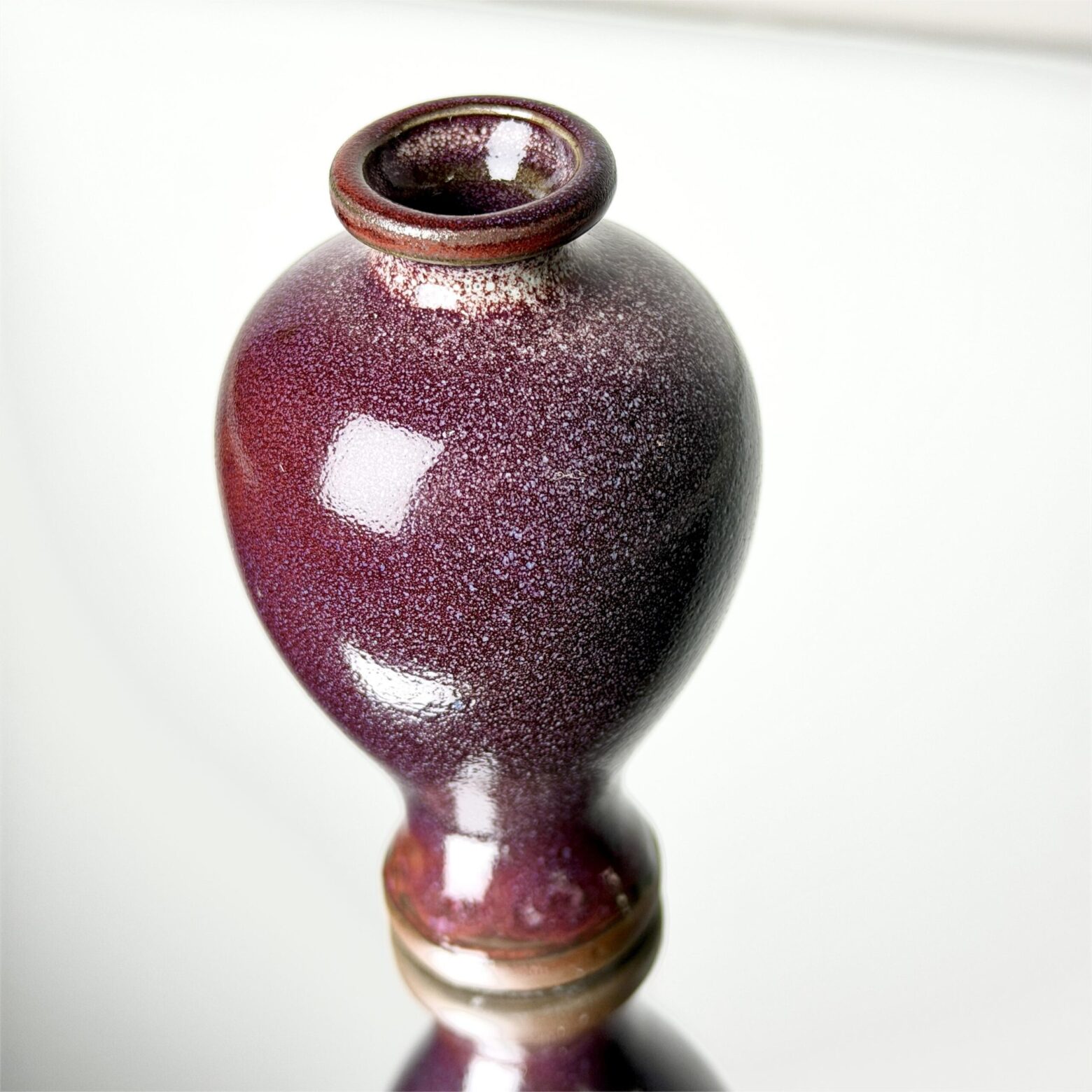 Full shape of handmade ceramic vase with red speckled glaze and elegant curved form, Yunnan China