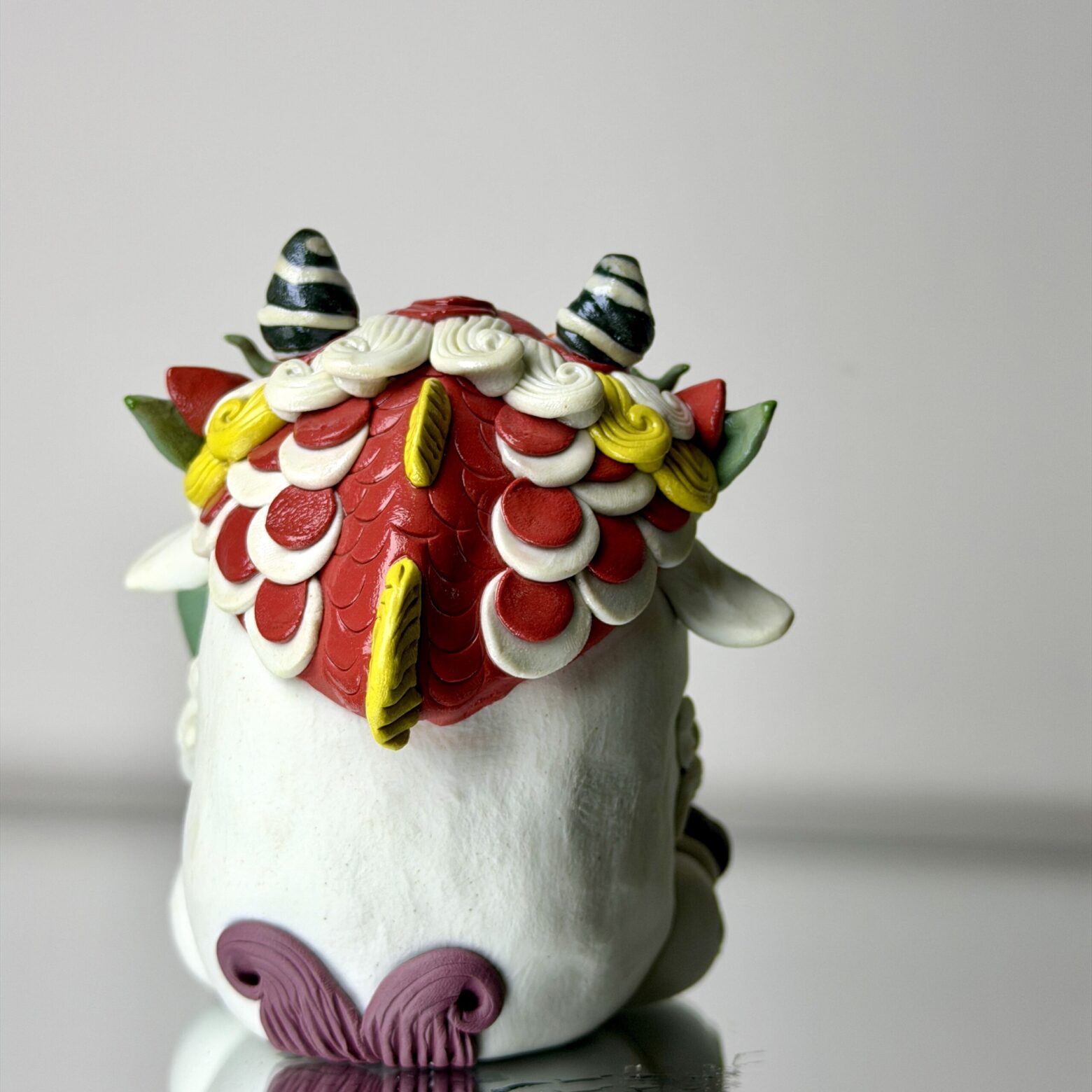 Back detail of handmade qilin ceramic figurine showing layered texture and hand-sculpted patterns