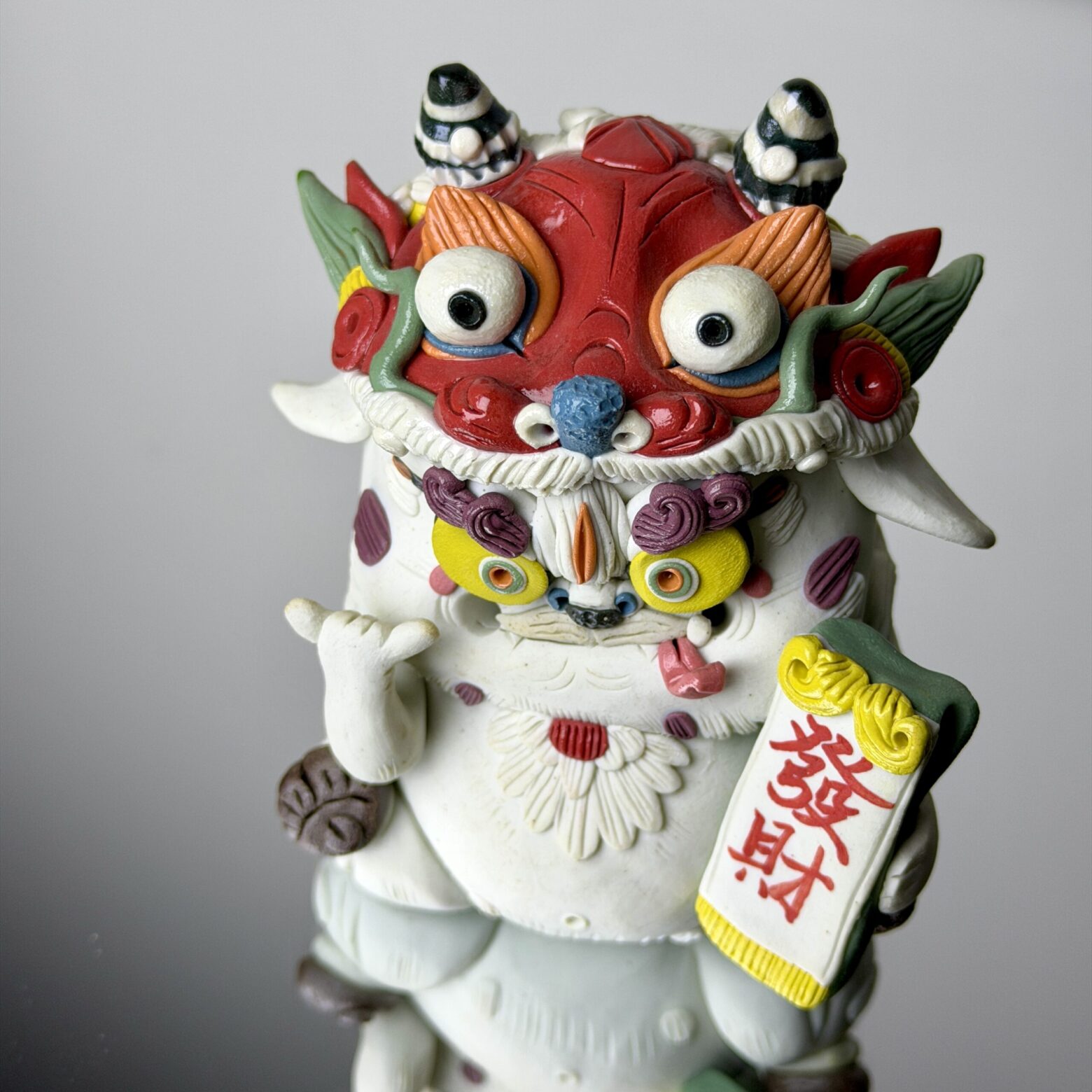 Handmade qilin ceramic figurine front view holding Chinese character fortune symbol, traditional lucky decoration