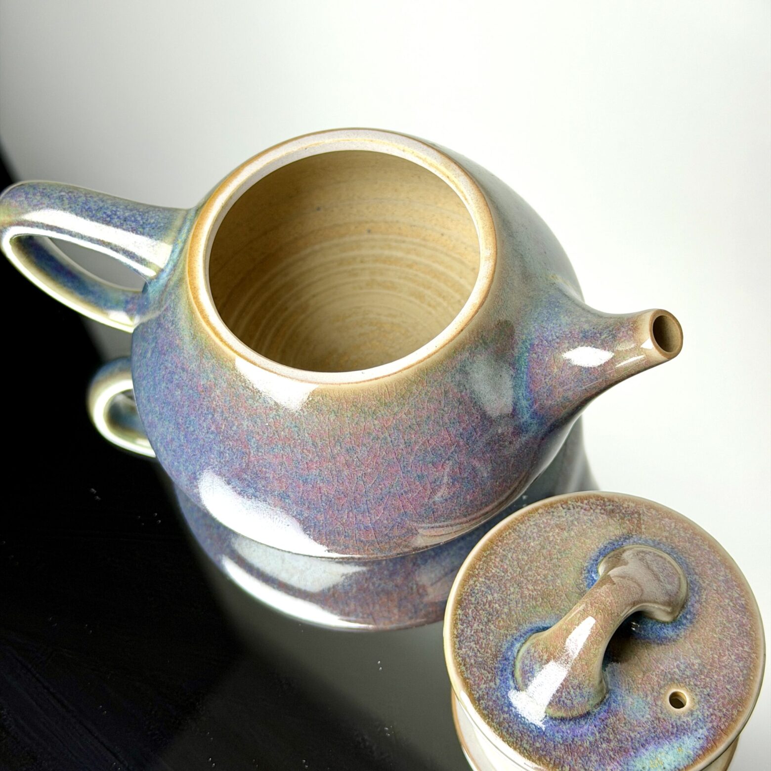 Open view of handmade ceramic teapot showing interior craftsmanship and natural glaze texture