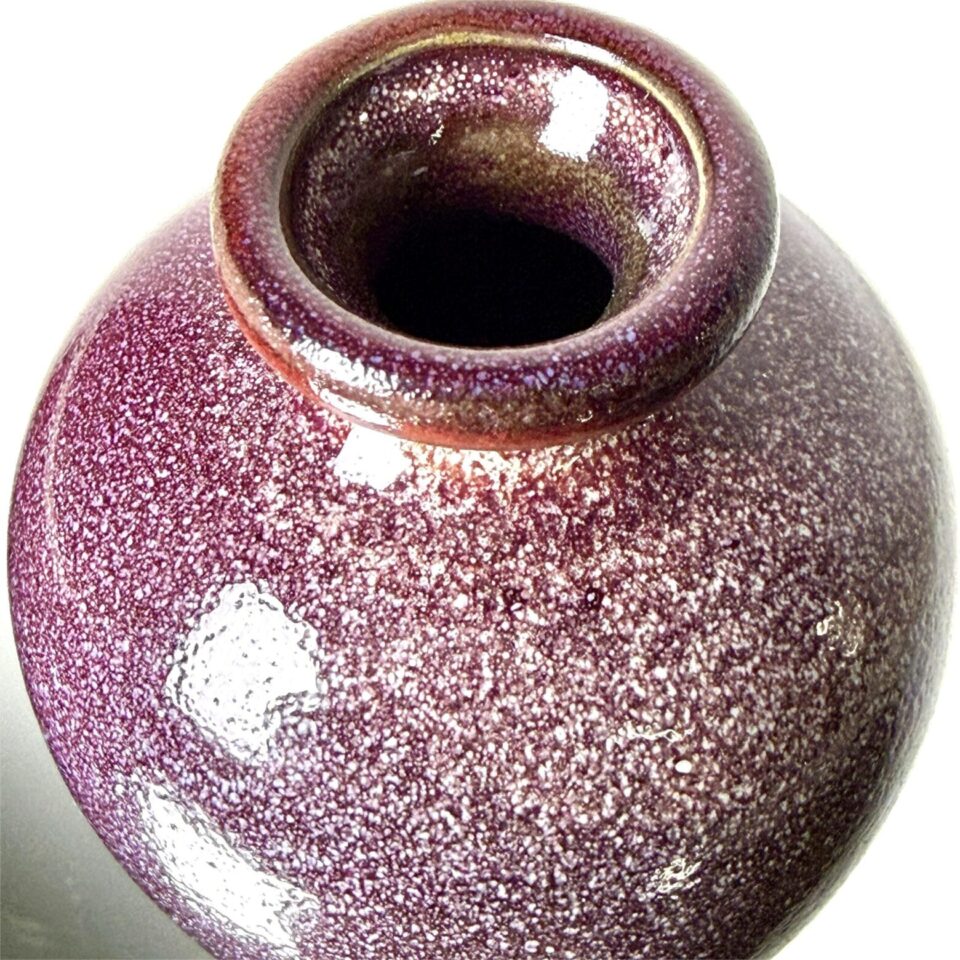 Detail of red crystalline glaze texture on handmade ceramic vase, high-fired Yunnan pottery